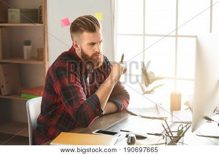 Young male architect working indoors thinking about project