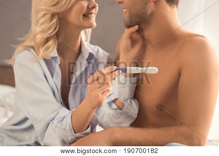 Young couple on bed pregnancy test check happy pregnant