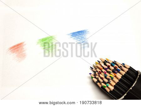 close up of spilled colored pencil container with red green and blue scribbles