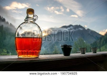 Drinking plum brandy after a long hiking tour in the mountains in Austria during sunset