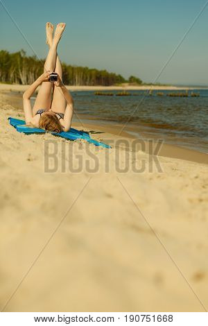 Woman In Bikini Sunbathing And Relaxing On Beach