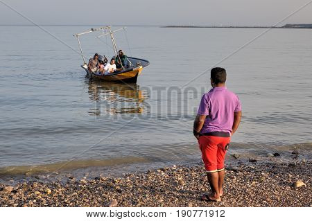 Bandar Abbas Hormozgan Province Iran - 16 april 2017: One man looks like a boat with an Iranian family aboard mooring to the shore.