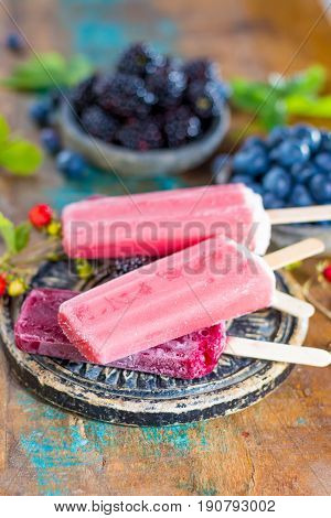 Fresh summer wild blueberries and brambleberry strawberry and home made sorbet ice cream popsicles.