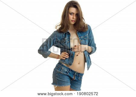 a charming young brunette in jeans dress erotic poses in the Studio isolated on white background