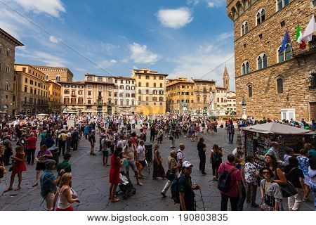 Florence ITALY- September 10 2016: View on Square of Signoria and Tower of Arnolfo in Florence (Piazza della Signoria) in Florence that is full of tourists who are walking on the old square