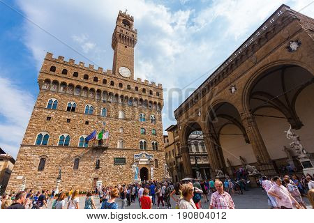 Florence ITALY- September 10 2016: View on Square of Signoria and Tower of Arnolfo in Florence (Piazza della Signoria) in Florence that is full of tourists who are walking on the old square
