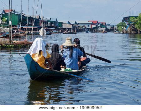 Boat and passengers at floating village, Kampong Phluk, Cambodia.