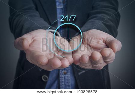 Businessman hand with symbol of on worldwide 24/7 service. Worldwide nonstop (full time 24/7) service concept.