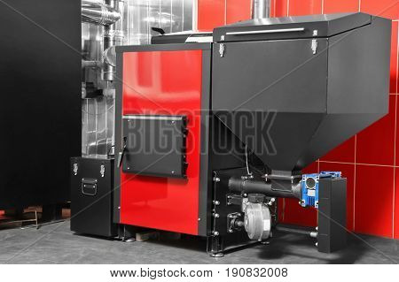 Solid fuel boiler against red wall