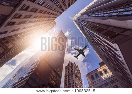 plane flying over multiple office skyskraper in the sun, Manhattan, New York City