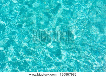 background textures of close up of blue and white water ripples and reflections of light in the swimming pool