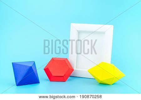 White Photo Frame(made From Paper) And Colourful Paper Jewels On Light Blue Background,modern Home D