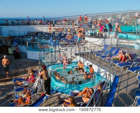 Miami, United States of America - January 12, 2014: The people resting at Carnival Glory Cruise Ship, the ship leaving Miami, USA on January 12, 2014. Carnival Glory is a Conquest-class cruise ship built in 2003 with capacity of 2974 passengers