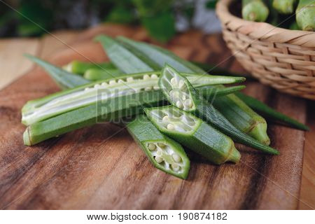 whole and portion cut fresh okra on cutting board