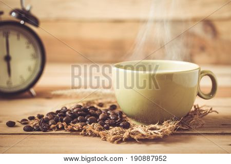 Morning Aroma Hot Black Coffee Or Americano And Arabica Coffee Bean With Smoke On Wood And Clock Bac