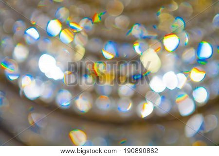 Chandelier and glare blurred focus. The colors are yellow blue red green orange. Soft focus