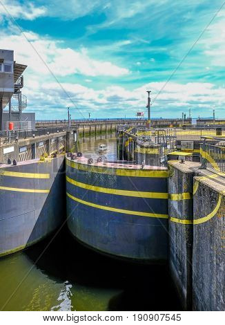 Lock opening at the Barage at Cardiff Bay. Shows small boat entering.