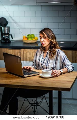 Young Woman Drinking Coffee And Working At Home