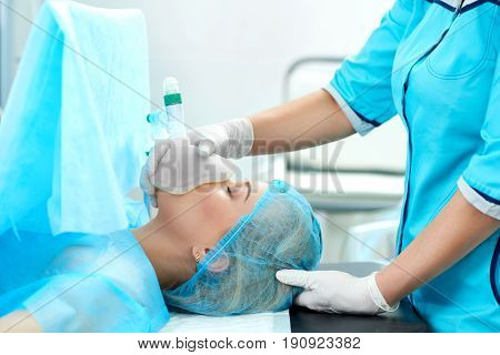 Cropped shot of a nurse holding oxygen mask for a female patient during surgery healthcare living profession help assistance health operation medicine clinic treatment concept.