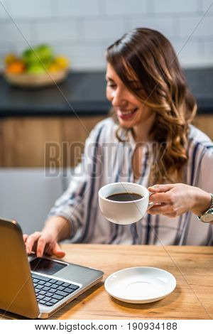 Young Woman Drinking Coffee And Working At Home