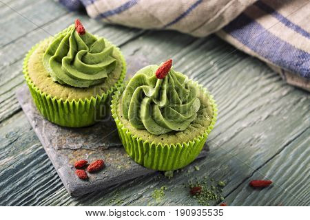 Matcha cup cakes on a wooden background