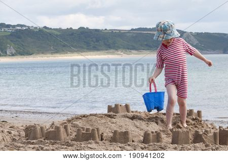Oxwich beach, Wales, 14-08-2010: A young kid building a sand castle on the beach in Wales.
