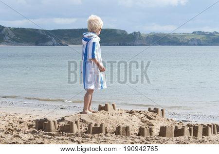 Oxwich beach, Wales, 14-08-2010: A young boy building a sand castle on the beach in Wales.