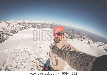 Adult Alpin Skier With Beard, Sunglasses And Hat, Taking Selfie On Snowy Slope In The Beautiful Ital