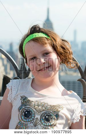 View of a Beautiful young girl on observation deck overlooking the lower Manhattan New York City skyline