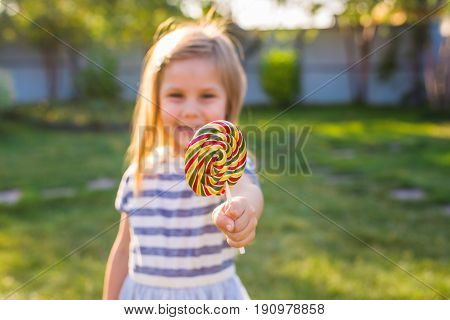 cute cauasian baby girl and big lollipop.