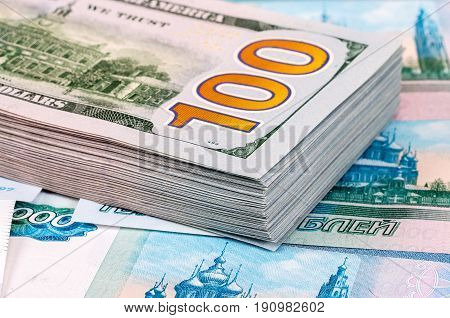 Stack of one hundred american dollar banknotes over roubles background