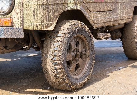 Dirty wheel of an off-road car after driving in the rain