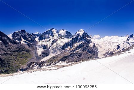 Snowy peaks of the Bernina range mountain tops under a clear blue sky seen from Corvatsch at 3303m. Corvatsch Engadin Grisons Switzerland