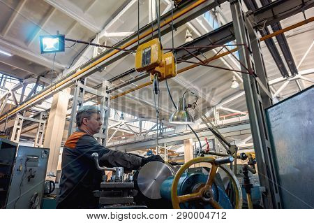 Turner Worker Manages The Metalworking Process Of Mechanical Cutting On A Lathe