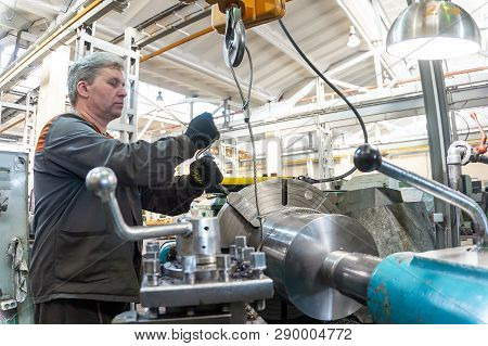 Turner Worker Manages The Metalworking Process Of Mechanical Cutting On A Lathe