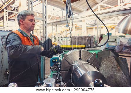 Turner Worker Manages The Metalworking Process Of Mechanical Cutting On A Lathe