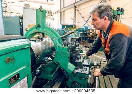 Turner Worker Manages The Metalworking Process Of Mechanical Cutting On A Lathe