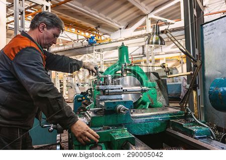 Turner Worker Manages The Metalworking Process Of Mechanical Cutting On A Lathe