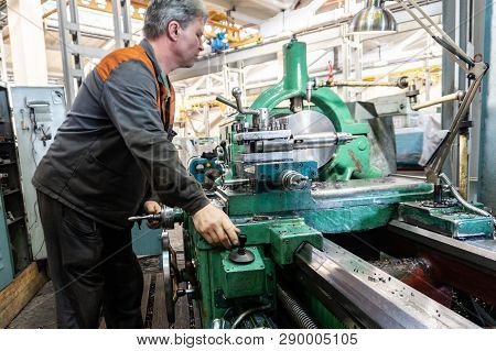 Turner Worker Manages The Metalworking Process Of Mechanical Cutting On A Lathe