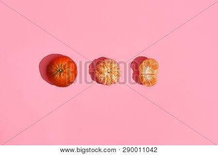 Food Design. Composition Of Whole Mandarin, Peeled Mandarin And Half Of Peeled Mandarin On Pink Cora