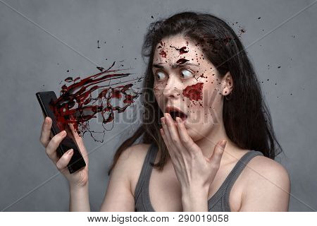 The Concept Of Insecurity, Spam, Social Problems .with Mobile Phone Flying Blood Splatter In The Fac