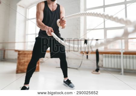 Strong Male Athlete Doing Exercises With Rope At Gym. Working Out With Battle Ropes At Cross Gym