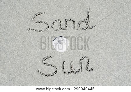 Beach Scene Of Sand And Sun Text With A Sand Dollar.  Concept Of Fun And Recreational Vacation Enjoy