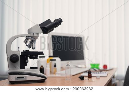 Laboratory Table With Microscope, Flasks And A Desktop Computer Above On A Window Light Background. 