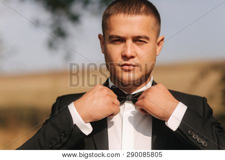 Handsome Groomm Dressed A Tie Bow. Wedding Day. Man Outside