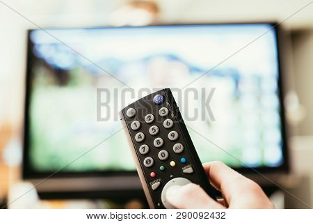 Male Hand Is Holding Tv Remote Control, Streaming On A Smart Tv.
