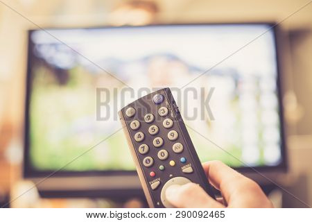 Male Hand Is Holding Tv Remote Control, Streaming On A Smart Tv.