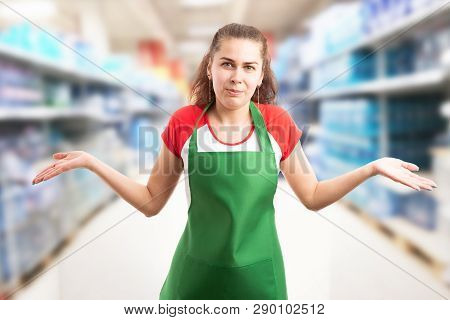 Female Hypermarket Or Supermarket Employee Making Confused Gesture With Palms Up And Expression As I