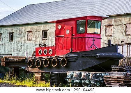 A Bright Red Dry Docked Tug Boat Outside A Marina In Middletown New Jersey.