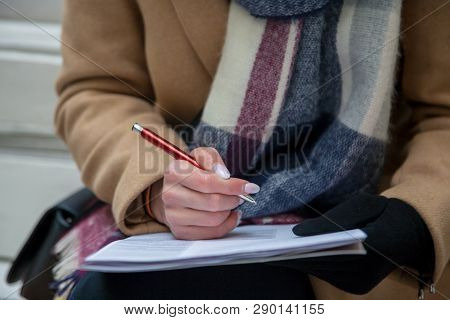 Woman Hand With Red Pen Completing A Form.